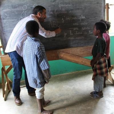 A Projects Abroad volunteer teaching his students on the black board in Madagascar. Students have group lessons with the volunteer teaching in Madagascar.